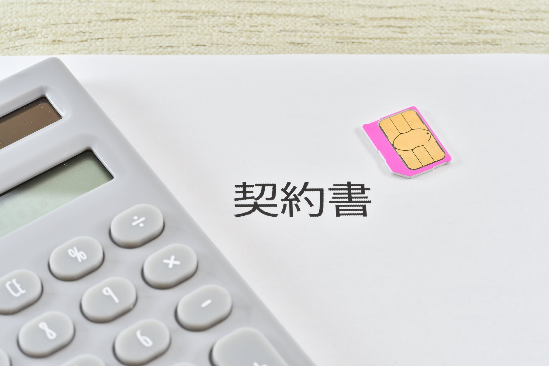 電卓と契約書に置かれたSIMカード
