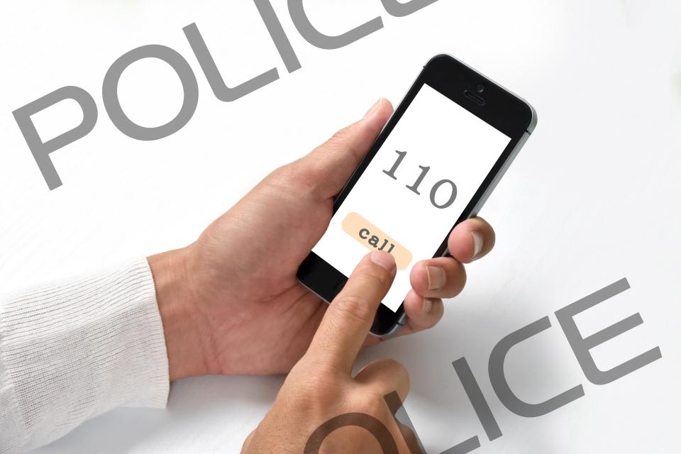 スマートフォンで警察に通報する手元