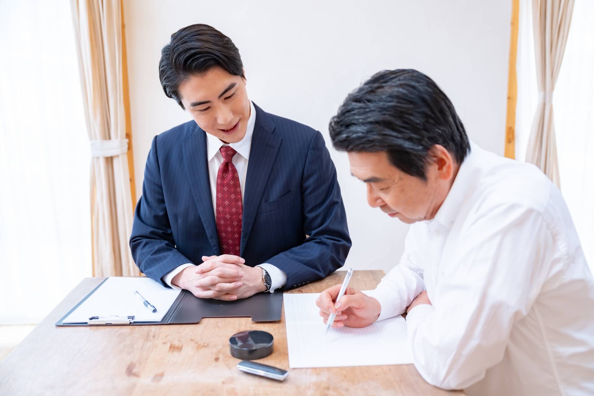 書類を確認するスーツ姿の二人
